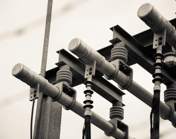 Selective Focus Greyscale Shot of Powerlines, Connections, and Transformers.